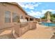 Built-in grill and bar near covered patio and rock pool in this outdoor kitchen at 2959 W Eastman Dr, Anthem, AZ 85086