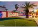 Beautiful putting green with pool and palm trees in the background at 3037 E Mallory St, Mesa, AZ 85213