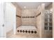 Bright bathroom featuring a tub with decorative tile, glass block window, and access to the toilet at 3037 E Mallory St, Mesa, AZ 85213