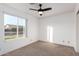 Cozy bedroom featuring a ceiling fan and large window, offering natural light and neighborhood views at 3037 E Mallory St, Mesa, AZ 85213