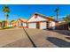 Home exterior featuring a three-car garage, low maintenance desert landscaping, and a tile roof at 3037 E Mallory St, Mesa, AZ 85213