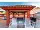 A stunning outdoor living space with comfortable seating, a grill, and a unique muraled wall for added charm at 3037 E Mallory St, Mesa, AZ 85213