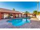 The backyard features a beautiful pool, complemented by lush landscaping and a charming tile-roofed house at 3037 E Mallory St, Mesa, AZ 85213