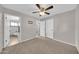 Comfortable carpeted bedroom features a ceiling fan and ensuite bathroom at 3124 W Port Royale Ln, Phoenix, AZ 85053