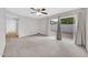 Spacious living room featuring neutral carpet, ceiling fan, and sliding door to backyard at 3124 W Port Royale Ln, Phoenix, AZ 85053