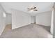 Inviting living room with neutral carpeting, ceiling fan, and ample space at 3124 W Port Royale Ln, Phoenix, AZ 85053