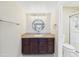 Bathroom featuring granite counters, dark wood vanity, large round mirror and a tiled shower at 3500 N Hayden Rd # 206, Scottsdale, AZ 85251