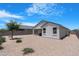 Landscaped backyard with gravel, privacy walls, and a covered patio at 35585 W San Alvarez Ave, Maricopa, AZ 85138