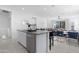 Open floor plan featuring a kitchen island with a stainless steel dishwasher and a view of the living space at 35585 W San Alvarez Ave, Maricopa, AZ 85138