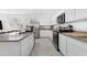 Well-lit kitchen showcasing white cabinets, stainless steel appliances and gray countertops at 35585 W San Alvarez Ave, Maricopa, AZ 85138