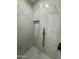 Modern bathroom featuring marble tile, rainfall shower head, and sleek black fixtures at 3627 W Palmaire Ave, Phoenix, AZ 85051