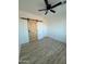 Bedroom with wood-look flooring, ceiling fan, and a rustic barn door at 3627 W Palmaire Ave, Phoenix, AZ 85051