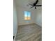 Bright bedroom with wood-look floors, ceiling fan, and a large window overlooking a natural desert landscape at 3627 W Palmaire Ave, Phoenix, AZ 85051