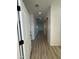 Bright hallway with wood-look floors and white doors, leading to a bedroom, bathroom, and other living areas at 3627 W Palmaire Ave, Phoenix, AZ 85051