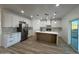 Modern kitchen with stainless steel appliances, large island, white cabinets, and wood-look floors at 3627 W Palmaire Ave, Phoenix, AZ 85051