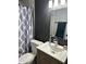 Clean bathroom features a single sink vanity, updated hardware, and shower with decorative curtain at 3646 N 67Th Ave # 64, Phoenix, AZ 85033