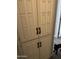 Hallway featuring built-in floor-to-ceiling storage cabinets with paneled doors and dark bronze colored pulls at 3646 N 67Th Ave # 64, Phoenix, AZ 85033