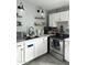 Well-lit kitchen boasts modern appliances, floating shelves, white cabinetry and a stainless steel sink at 3646 N 67Th Ave # 64, Phoenix, AZ 85033