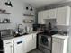 Well-lit kitchen boasts modern appliances, floating shelves, white cabinetry and a stainless steel sink at 3646 N 67Th Ave # 64, Phoenix, AZ 85033