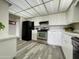 Well-lit kitchen featuring black appliances, wood-look flooring, and modern white cabinets at 425 S Parkcrest -- # 323, Mesa, AZ 85206