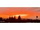 A sunset casts a colorful glow across the horizon, with trees silhouetted against a vibrant and dramatic sky at 425 S Parkcrest -- # 323, Mesa, AZ 85206