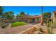 A private backyard featuring artificial turf, desert landscaping, a covered patio, and mature trees at 4346 E Bannock St, Phoenix, AZ 85044