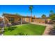 A well-maintained backyard with artificial turf, desert landscaping, a covered patio, and privacy fencing at 4346 E Bannock St, Phoenix, AZ 85044