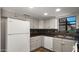 Bright kitchen features white appliances and cabinets with tiled backsplash and floors at 4346 E Bannock St, Phoenix, AZ 85044