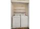 This laundry room features side by side washer and dryer with storage shelves at 4346 E Bannock St, Phoenix, AZ 85044