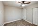 Simple bedroom with modern carpet, a ceiling fan, and two closets with doors at 5222 N 41St Ave, Phoenix, AZ 85019