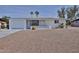 Charming single-story white home with a well-manicured yard and desert landscaping at 5510 E Dallas St, Mesa, AZ 85205