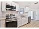 Well-lit kitchen with stainless steel appliances, quartz countertops, and updated cabinets at 5510 E Dallas St, Mesa, AZ 85205