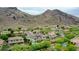 Stunning aerial view of the home with mountain backdrop, complemented by a refreshing pool and lush greenery at 5812 W Spur Dr, Phoenix, AZ 85083