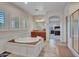 Bright bathroom boasts soaking tub, tiled floor, vanity, and view to bedroom and glass shower at 5812 W Spur Dr, Phoenix, AZ 85083