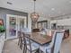 Open dining area with stylish light fixture, wood table, and easy access to outdoor patio at 5812 W Spur Dr, Phoenix, AZ 85083