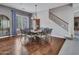 Dining room with dark wood floors, stylish chandelier, and an iron staircase, complemented by abundant natural light at 5812 W Spur Dr, Phoenix, AZ 85083
