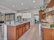 Open-concept kitchen features a large island, wood cabinets, stainless appliances, and herringbone tile backsplash at 5812 W Spur Dr, Phoenix, AZ 85083