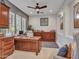 Well-lit office with custom wood cabinets, desk, ceiling fan, and window shutters providing an inviting workspace at 5812 W Spur Dr, Phoenix, AZ 85083