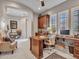 Open concept office with custom wood built-ins, desk, comfortable seating, and views to an adjacent living space at 5812 W Spur Dr, Phoenix, AZ 85083