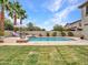 An inviting pool, surrounded by lush palm trees and stone accents, creates a serene backyard oasis at 5812 W Spur Dr, Phoenix, AZ 85083