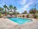 Sparkling pool with waterfall feature and palm trees creating a backyard oasis at 5812 W Spur Dr, Phoenix, AZ 85083