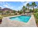 Backyard pool featuring a stone waterfall, lounge chairs, and lush landscaping with a mountain view at 5812 W Spur Dr, Phoenix, AZ 85083