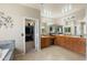 A bathroom area with double sink vanity, large mirror, tile flooring, and walk in closet at 6202 W Maya Dr, Phoenix, AZ 85083