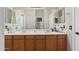 Bathroom featuring a double sink vanity with a large mirror and wood cabinets at 6202 W Maya Dr, Phoenix, AZ 85083