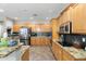 Modern kitchen featuring stainless steel appliances, granite countertops, and wooden cabinetry at 6202 W Maya Dr, Phoenix, AZ 85083