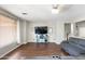 Inviting living room with hardwood floors, ceiling fan, and large television at 6202 W Maya Dr, Phoenix, AZ 85083