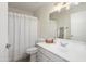 This well-lit bathroom features a shower with a shower curtain, a mirror, a sink, and a toilet at 6366 W Saint John Ave, Glendale, AZ 85308