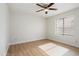 Well-lit bedroom featuring laminate floors, a ceiling fan, and a window, blending style with comfort at 6366 W Saint John Ave, Glendale, AZ 85308
