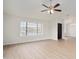 Stylish living room with modern ceiling fan, light-colored floors, and bright natural light from large windows at 6366 W Saint John Ave, Glendale, AZ 85308
