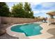 Well-maintained pool surrounded by lush greenery and a brick wall, offering a private and inviting outdoor space at 6366 W Saint John Ave, Glendale, AZ 85308